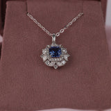  Claw set 18ct white gold pendant with natural blue sapphire gemstone and marquise and round brilliant cut diamond halo detail.