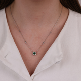 18ct white gold emerald and diamond necklace worn around the neck showing rich green colour and sparkle.