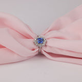 Top view of 18ct white gold fancy halo dress ring showcasing the symmetrical diamond halo surrounding a natural blue sapphire.