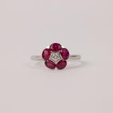 18ct white gold flower style ring featuring five natural oval shaped rubies and diamond accent available at York Jewellers Penrith and Warriewood (Sydney). 