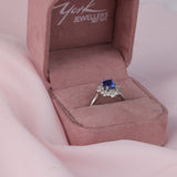 18ct white gold fancy halo dress ring featuring natural emerald cut blue sapphire and round brilliant cut diamonds available at York Jewellers Penrith and Warriewood (Sydney).