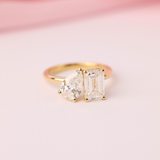 Tahlia engagement ring featuring pear shape and emerald cut diamonds yellow gold band.