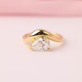 Phoebe engagement ring featuring pear shape centre diamond yellow gold band.