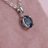 Side view of claw set 9ct white gold pendant with natural London blue topaz gemstone detail.