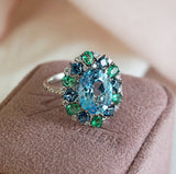 Sky Blue Topaz, Emerald & London Blue Topaz Fancy Halo Ring