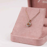 18ct two-tone yellow and white gold pendant featuring a 0.50ct round yellow sapphire surrounded by a diamond halo.