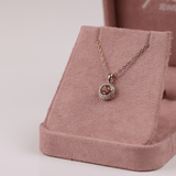 18ct two-tone yellow and white gold pendant featuring a 0.50ct round yellow sapphire surrounded by a diamond halo.