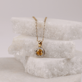 Elegant 18ct gold pendant with round yellow sapphire centre stone and surrounding round brilliant cut diamonds available at York Jewellers Penrith and Warriewood. 