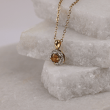 Two-tone gold halo pendant with yellow sapphire gemstone and delicate diamond surround on fine chain available at York Jewellers Penrith.