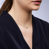 On-body shot of 9ct yellow gold pendant showcasing a certified bezel set natural Australian yellow sapphire, available at York Jewellers Penrith.