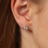 9ct white gold aquamarine and diamond halo stud earrings worn on the ear showing sky blue colour and diamond sparkle, available at York Jewellers Penrith.
