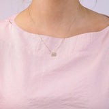 9ct yellow gold Aquarius diamond pendant worn at the collarbone showing the water bearer symbol and diamond detail.