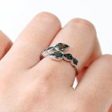 9ct white gold Ariel Ring worn on hand showing the flowing wrap design and shifting teal sapphire colour.