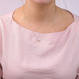9ct yellow gold Aries diamond pendant worn at the collarbone showing the ram symbol and diamond detail.