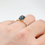 18ct yellow gold Camilla Ring worn on hand showing the alternating diamond band and blue sapphire centre stone.