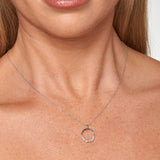 9ct white gold diamond circle pendant worn at the collarbone showing polished sparkle, available at York Jewellers Penrith.
