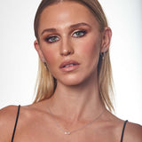 9ct white gold diamond huggie drop earrings worn on the ear showing movement and sparkle.