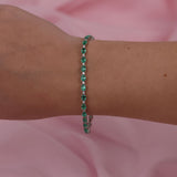 Close-up of 18ct white gold tennis bracelet showcasing claw set natural oval emeralds and diamonds, available at York Jewellers Penrith.