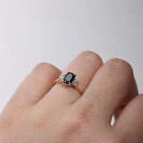 18ct yellow gold Endota Ring worn on hand showing the trilogy design and shifting teal sapphire colour, available from Sydney fine jeweller York Jewellers.