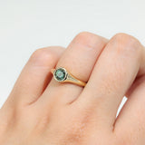 Close-up of 9ct yellow gold ring showcasing a round brilliant cut natural Australian teal sapphire, available at York Jewellers Penrith.