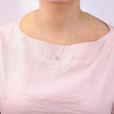 9ct yellow gold Libra diamond pendant worn at the collarbone showing the scales symbol and diamond detail.
