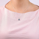 9ct white gold London blue topaz pendant worn at the collarbone showing deep blue gemstone colour.