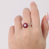 18ct white gold ruby flower ring worn on hand showing vibrant red gemstones and elegant floral design.