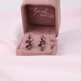 Close-up of 18ct white gold leaf style earrings showcasing 4.06ct total natural rubies and round brilliant cut diamond detail available at York Jewellers Penrith.