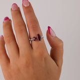 18ct white gold ruby split ring worn on hand showing two vivid red gemstones and split band design.