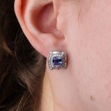 18ct white gold sapphire double halo stud earrings worn on the ear showing rich blue gemstones and layered diamond sparkle.