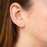9ct white gold open circle diamond stud earrings worn on the ear, ideal for layering or wearing alone.