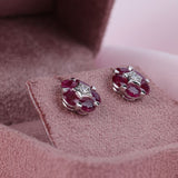 Close-up of 18ct white gold stud earrings with 2.35ct total natural oval rubies and round brilliant diamonds available at York Jewellers Penrith. 