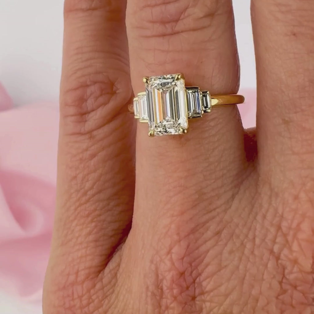 Emerald cut diamond engagement ring on hand yellow gold Sydney.