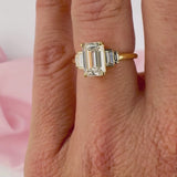Emerald cut diamond engagement ring on hand yellow gold Sydney.