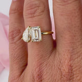 Pear shape and emerald cut diamond engagement ring on hand yellow gold Sydney.