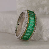 Detail shot of round brilliant cut diamonds (0.29ct total, H/SI) set alongside natural emeralds on an 18ct white and yellow gold ring.
