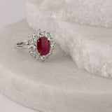 Front  profile of 18ct white gold halo flower style ring showing natural oval ruby and layered diamond detailing.