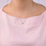 9ct yellow gold Sagittarius diamond pendant worn at the collarbone showing the archer symbol and diamond detail.