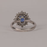 Back profile of 18ct white gold fancy halo dress ring showing emerald cut natural blue sapphire and diamond detailing.