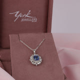 Close-up of 18ct white gold pendant showcasing 1.62ct natural square emerald cut blue sapphire and surrounding diamond halo available at York Jewellers Penrith.