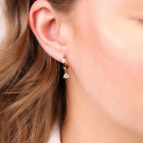 On-ear view of 0.30ct EF/VS lab grown trilliant cut diamonds in 9ct yellow gold bezel set drop huggie earrings available at York Jewellers Penrith and Warriewood (Sydney).