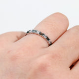 Close-up of 18ct white gold ring showcasing alternating baguette teal sapphires and round brilliant diamonds, available at York Jewellers Penrith.